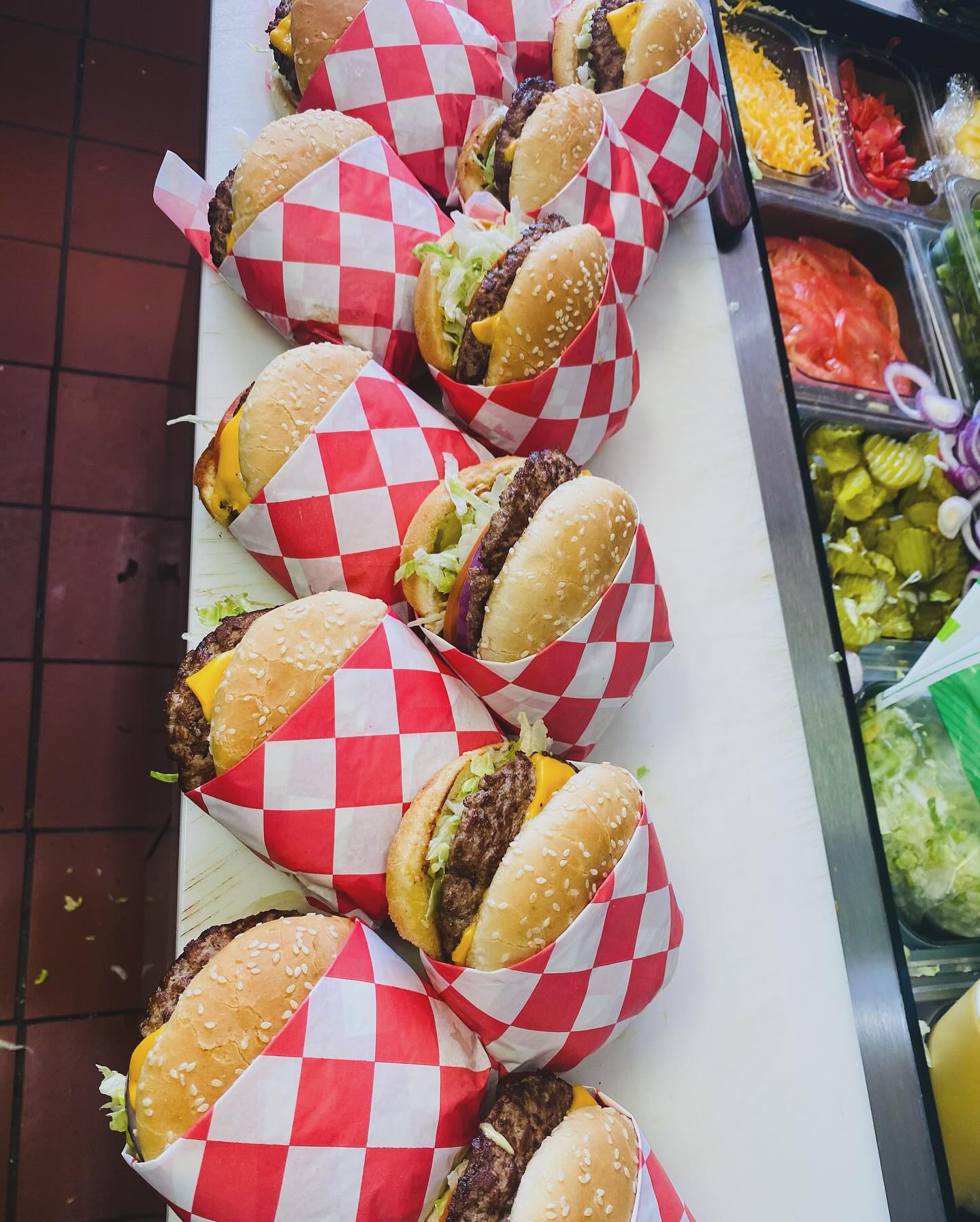 Catering spread - overhead view of wrapped burgers and condiment station