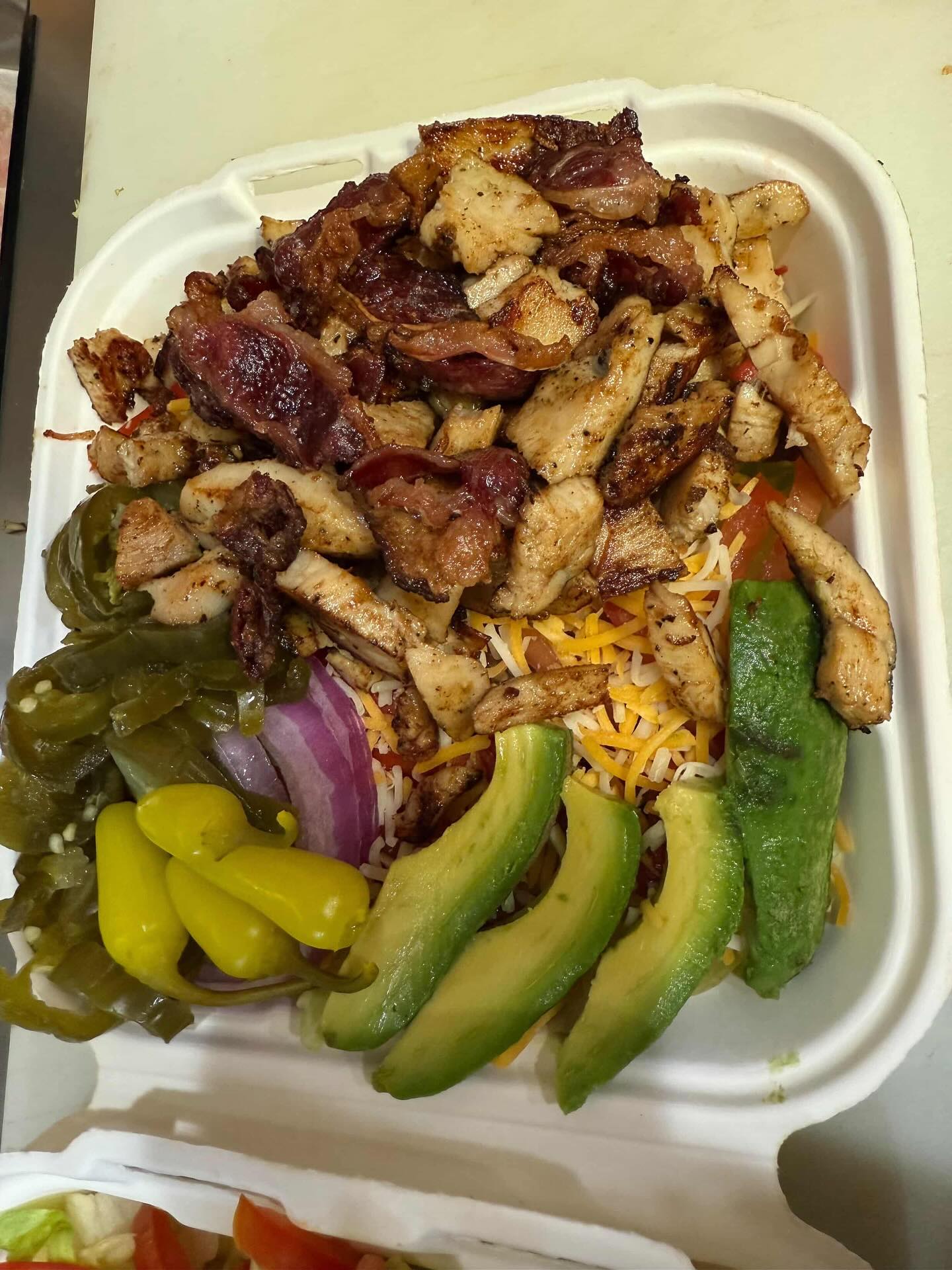 Grilled chicken bowl with beef bacon, avocado, jalapenos, and shredded cheese