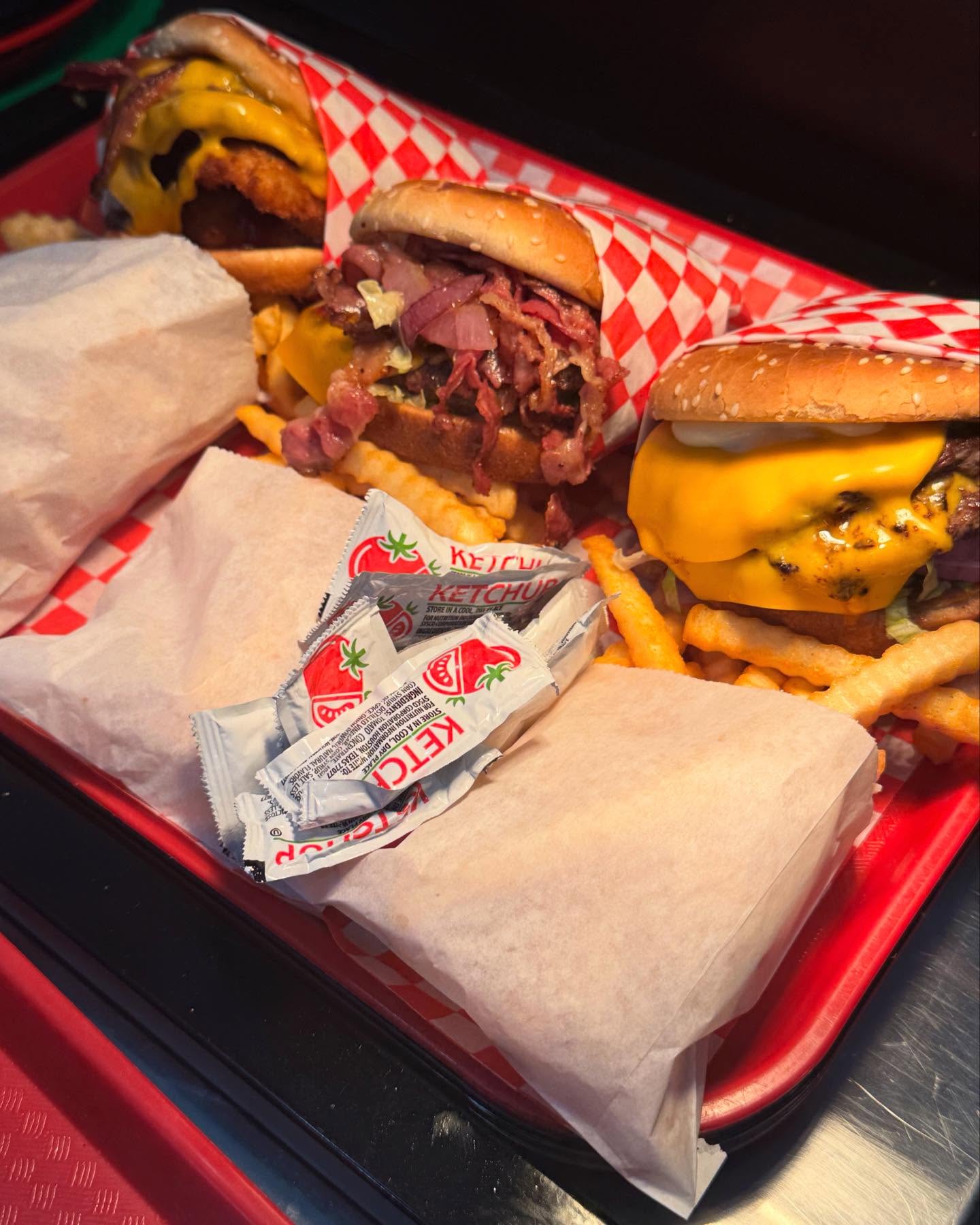 Red tray combo meal with pastrami burger, cheeseburger, and crinkle fries