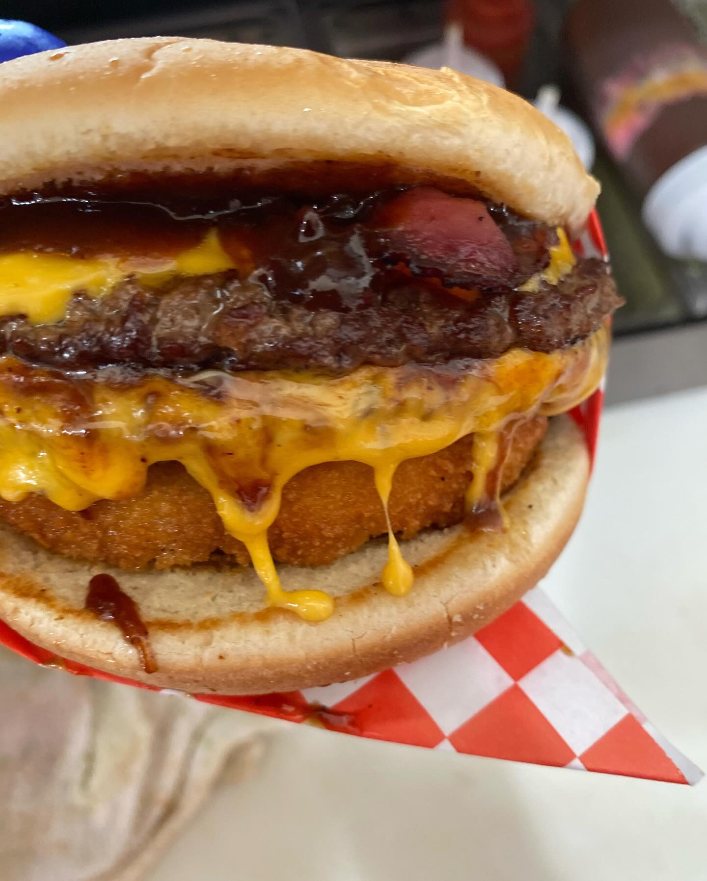 Specialty burger with fried hash brown insert, hot dog, and BBQ sauce