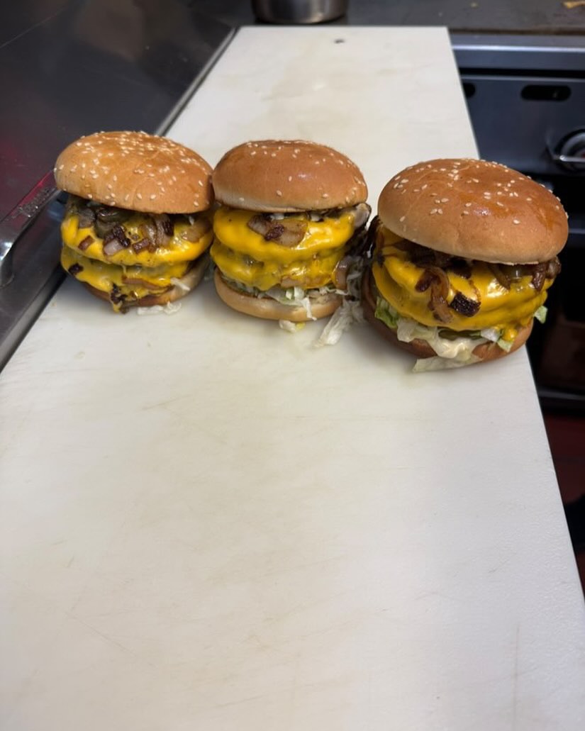 Triple double cheeseburgers with caramelized onions on the prep line